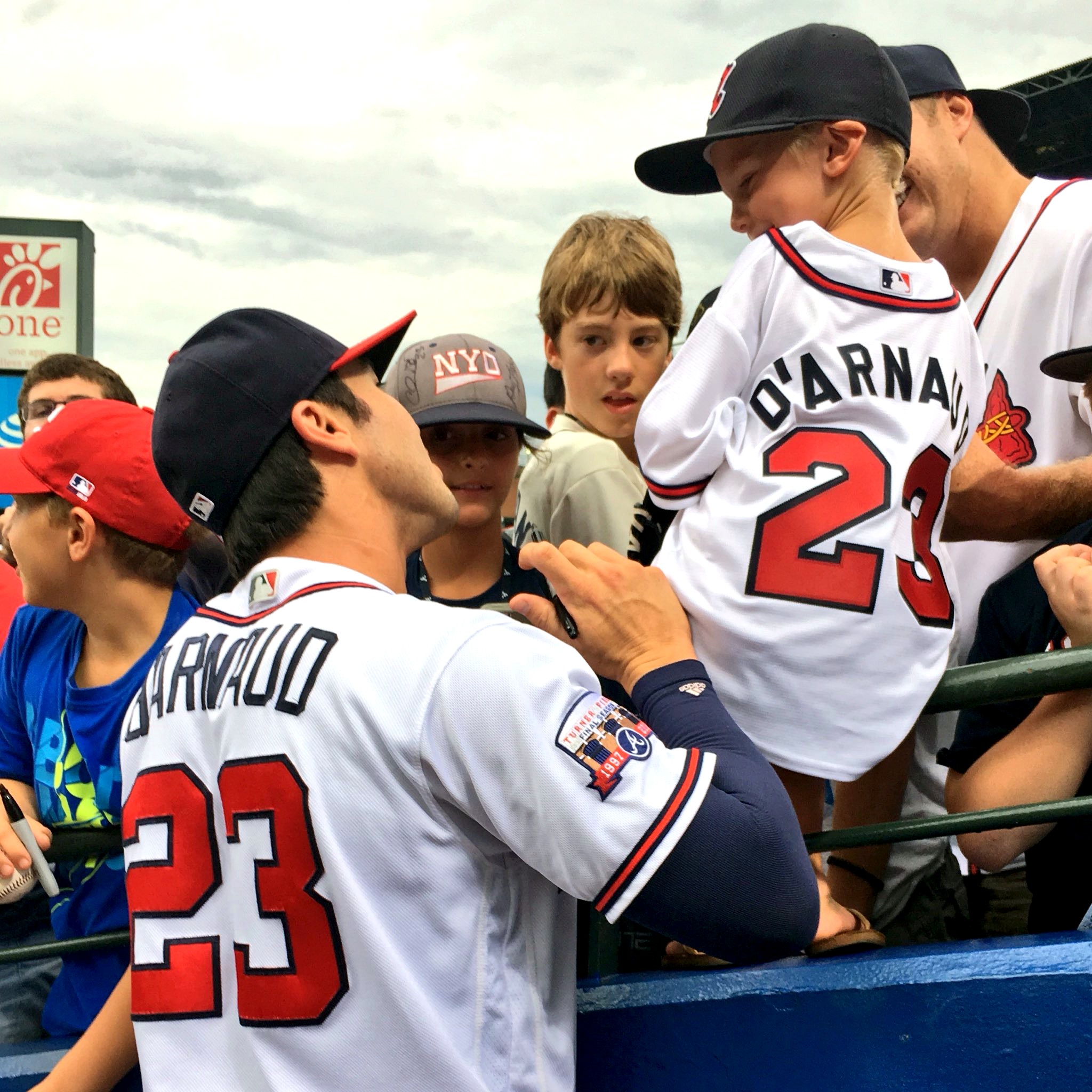 Chase d'Arnaud in an Atlanta Braves jersey greets a young fan wearing his number 23 jersey.